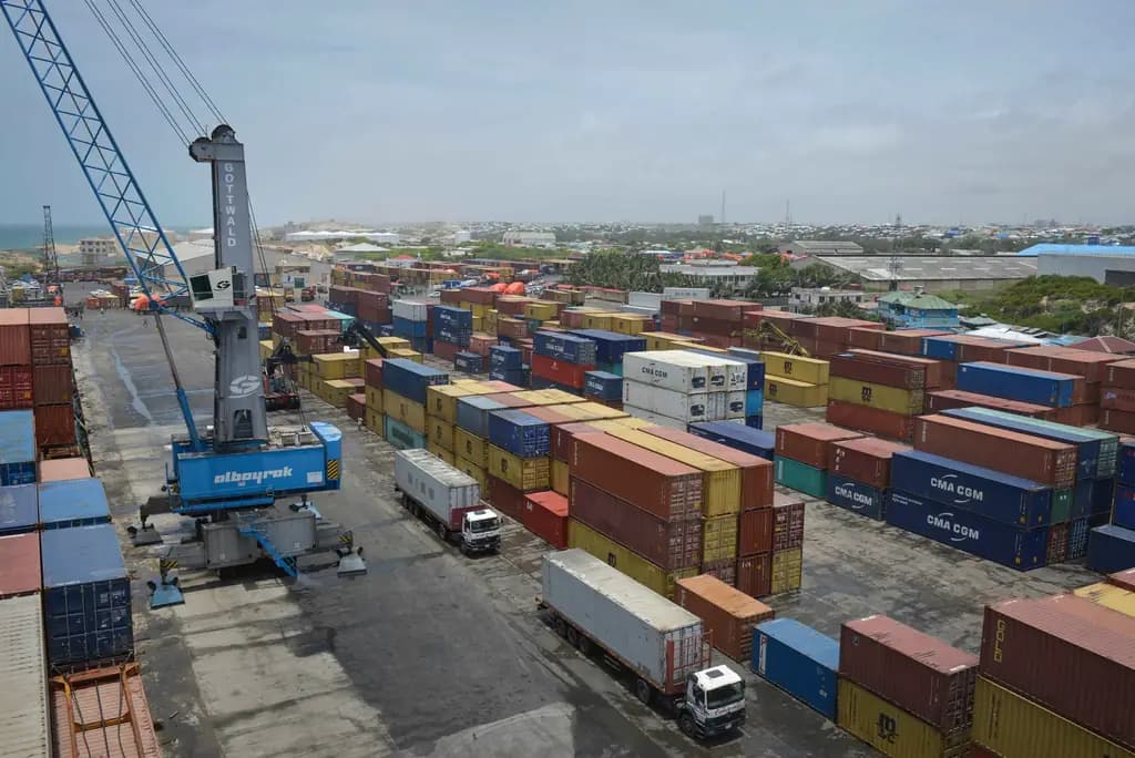 Stacked shipping containers and waiting trucks at an East African port